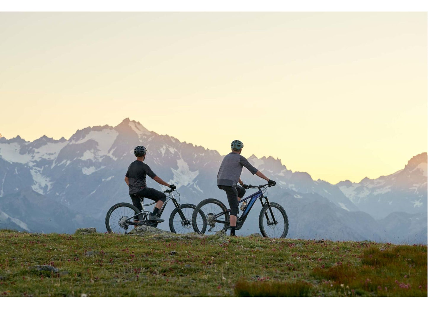 Giant Stance E plus 1 eMTB full suspension two men riding with mountains sunset in background