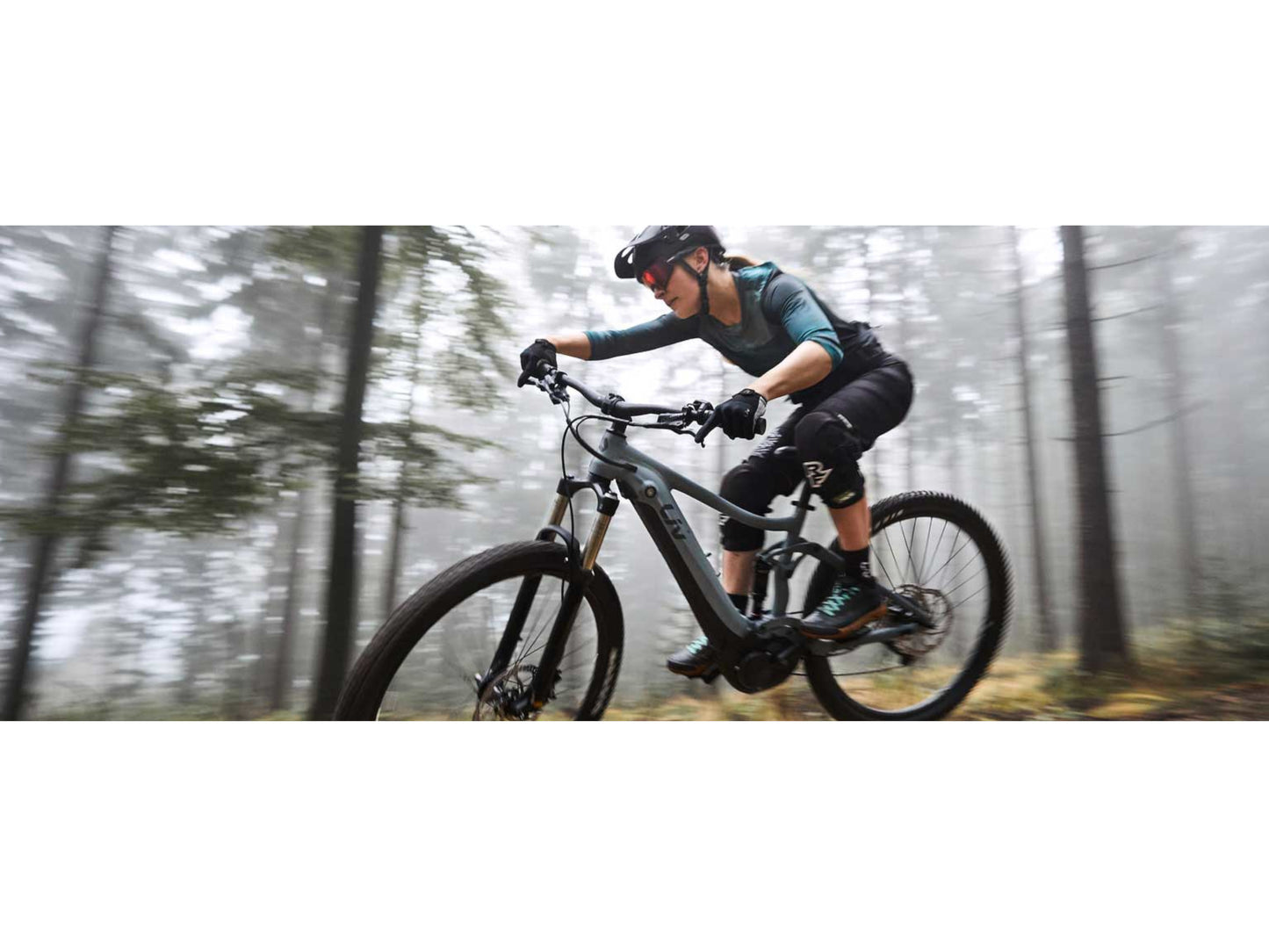 Liv Embolden E+ 2 eMTB full suspension Cosmos Navy Black woman riding trail in forest