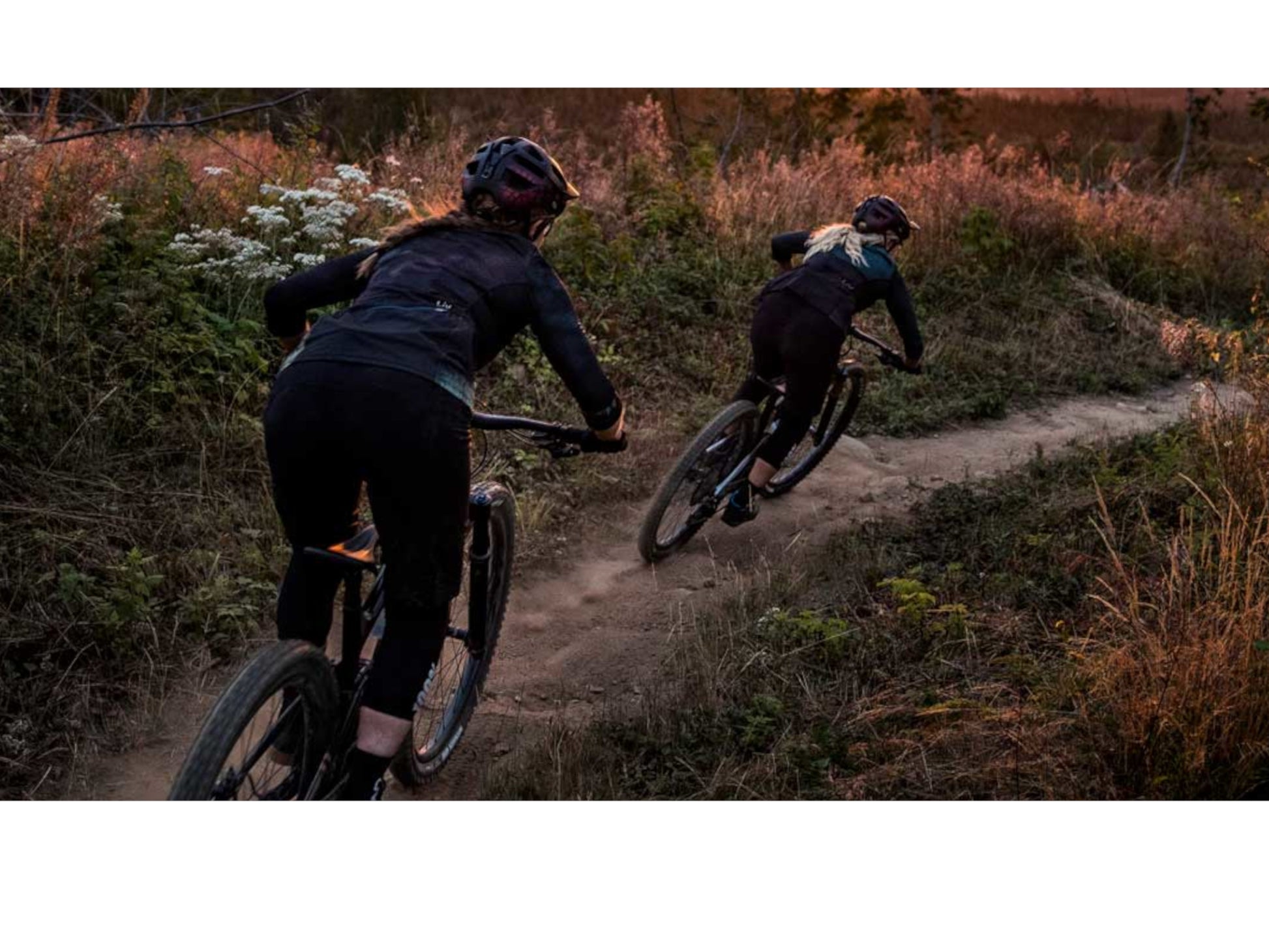 Liv Embolden  E+ 2 eMTB full suspension woman and man riding downhill at dusk