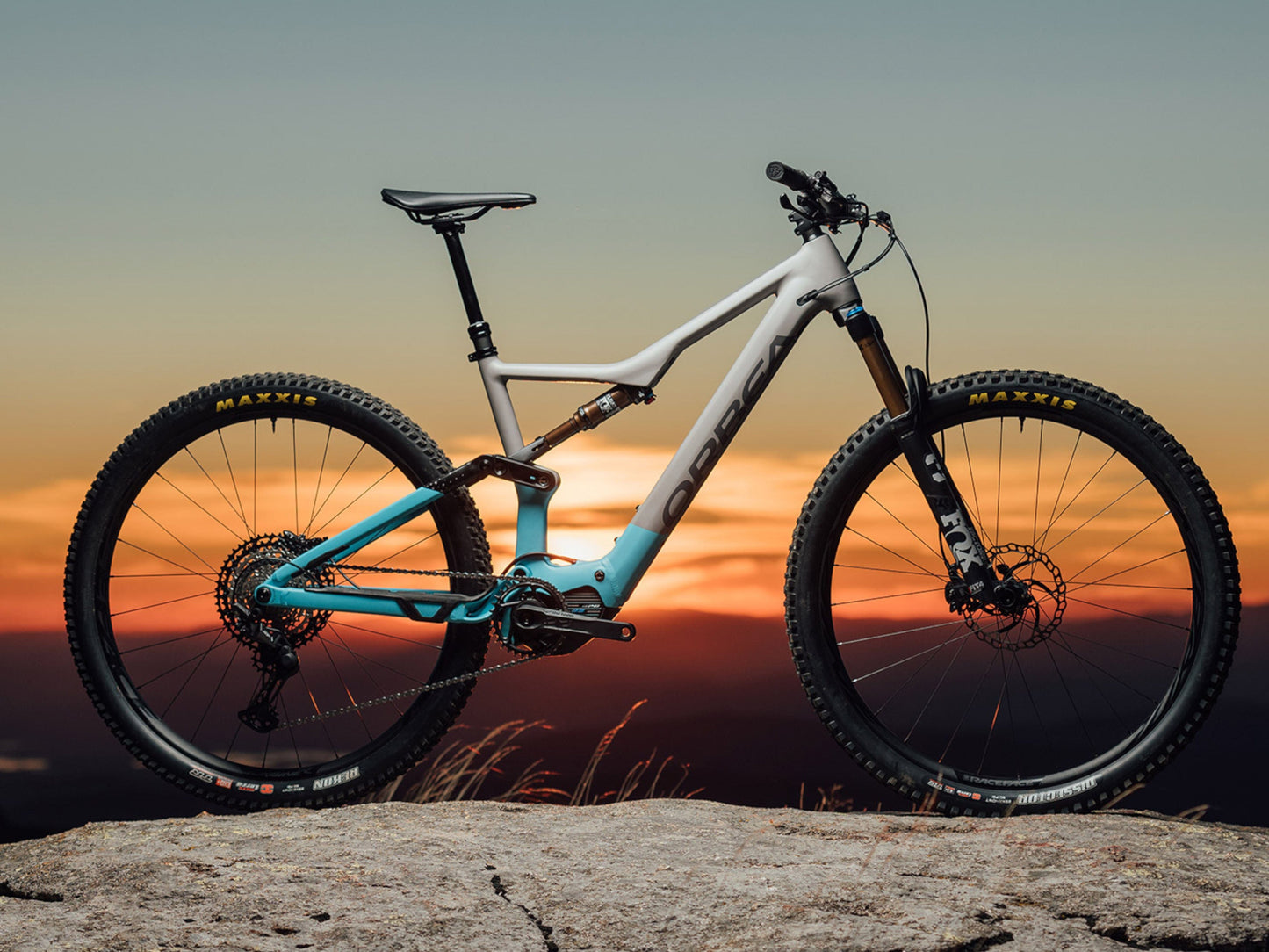 Orbea Rise Hydro H30 eMTB in grey and blue sunset background side view